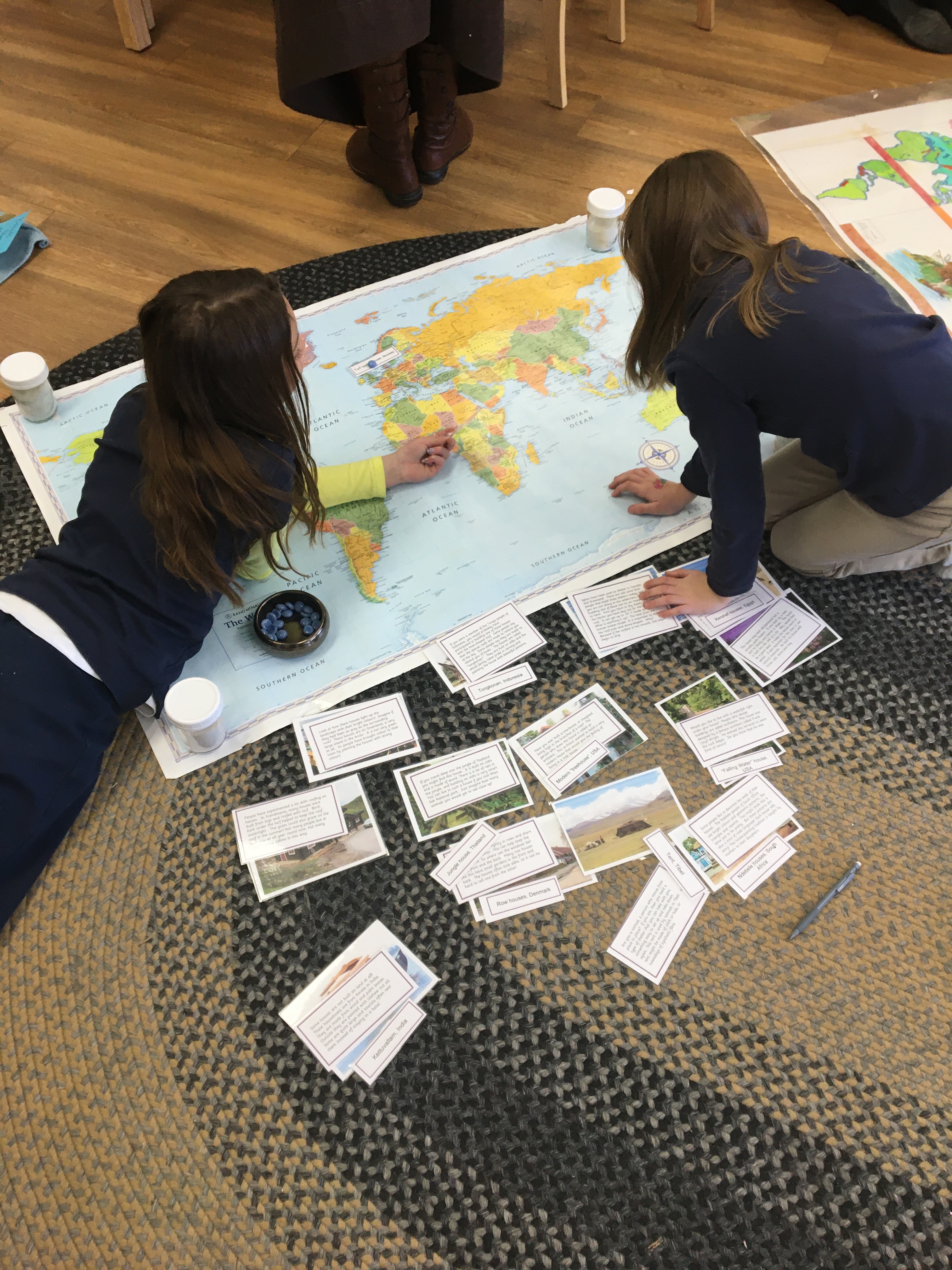 children on floor with map of the world