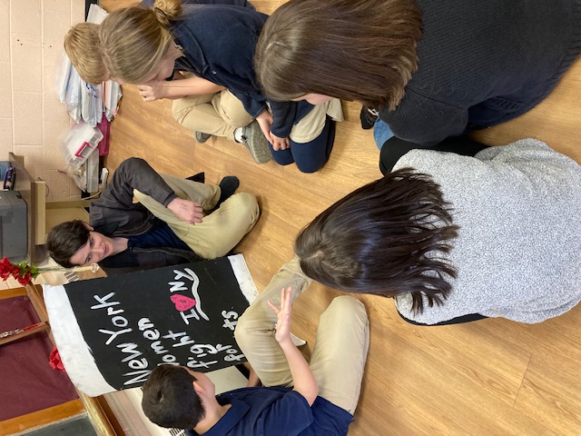 children sitting on floor discussing womens rights