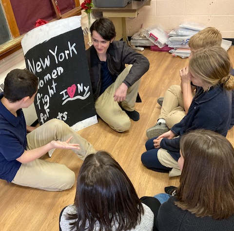 children sitting on floor disucssing womens rights