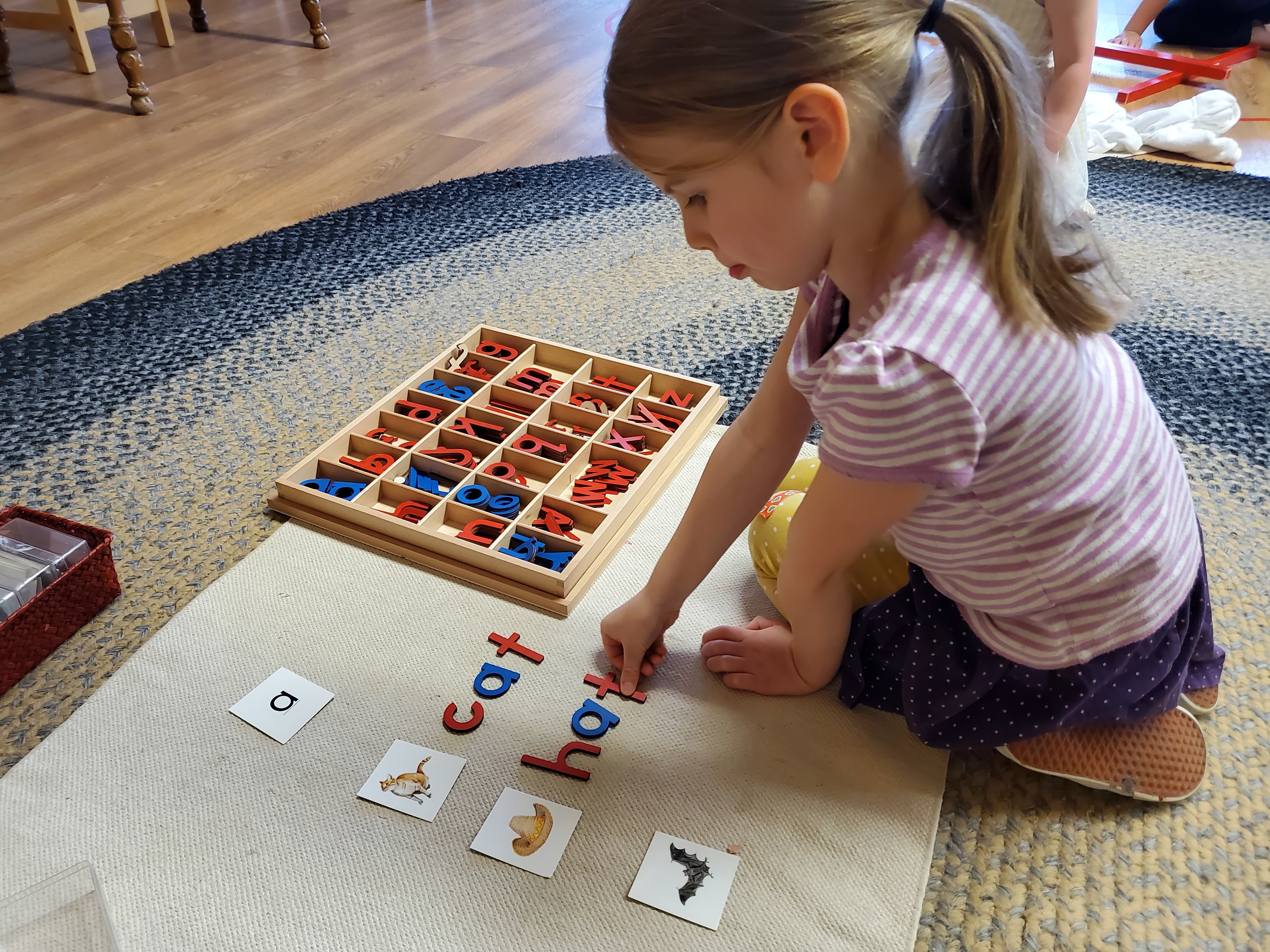 child matching letter tiles to pictures