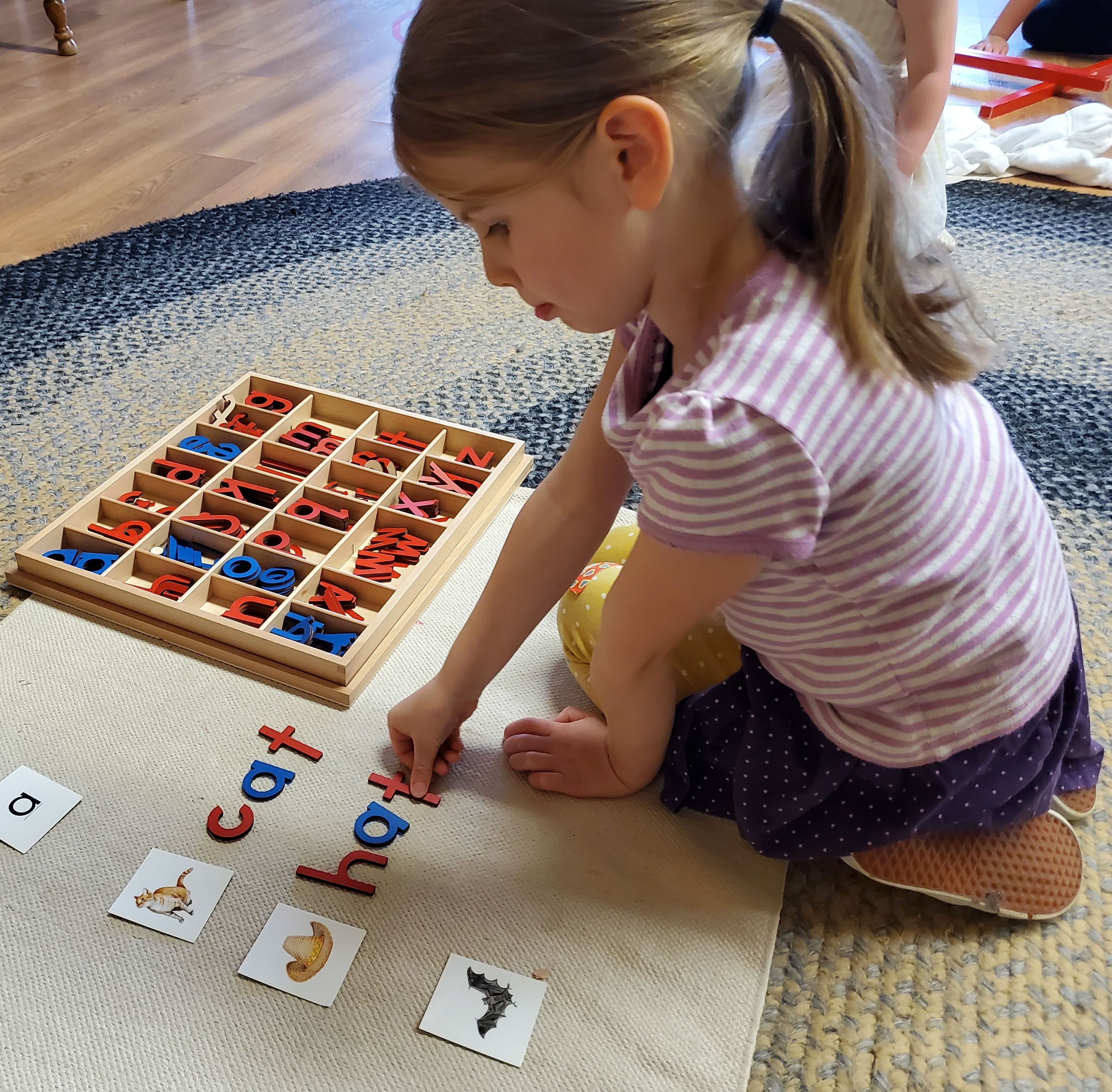 child matching letter tiles to pictures