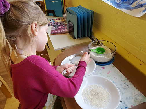 child sifting through sand